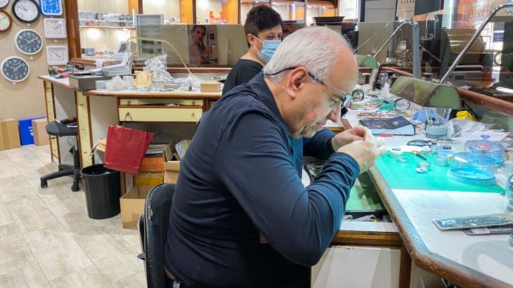 Detalle del relojero trabajando en el taller del establecimiento emblemático Rellotgeria Catalana